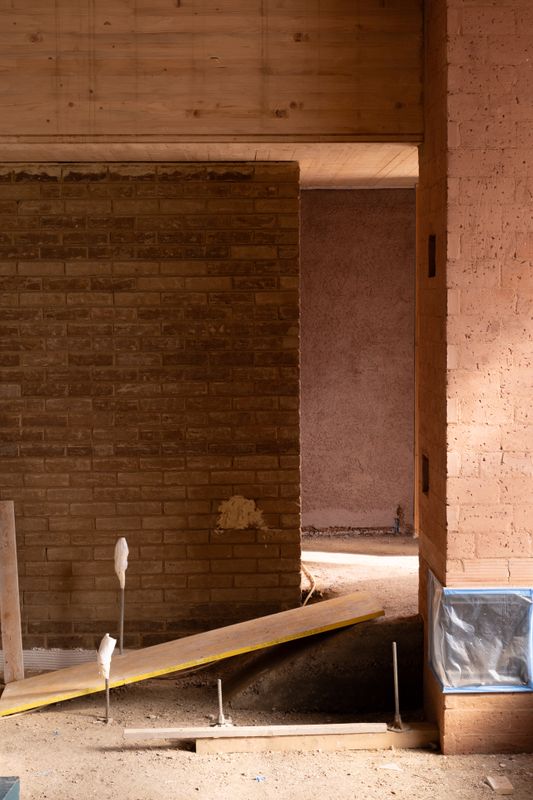 Gässli 5 – Ungebrannte Lehmziegel, rezyklierter Ziegelputz und ein Boden aus Stampflehm prägen den Innenraum. – Allen + Crippa